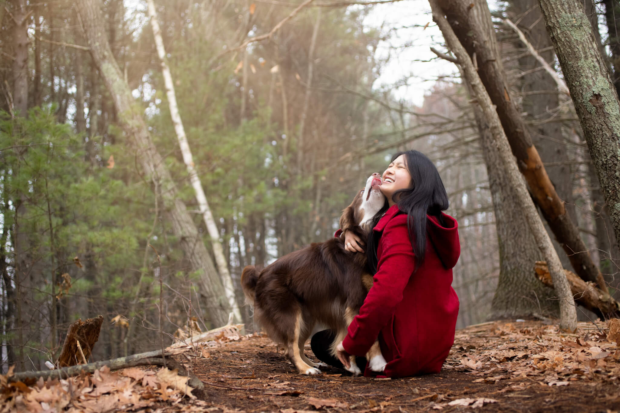 woman in red being kissed by her dog