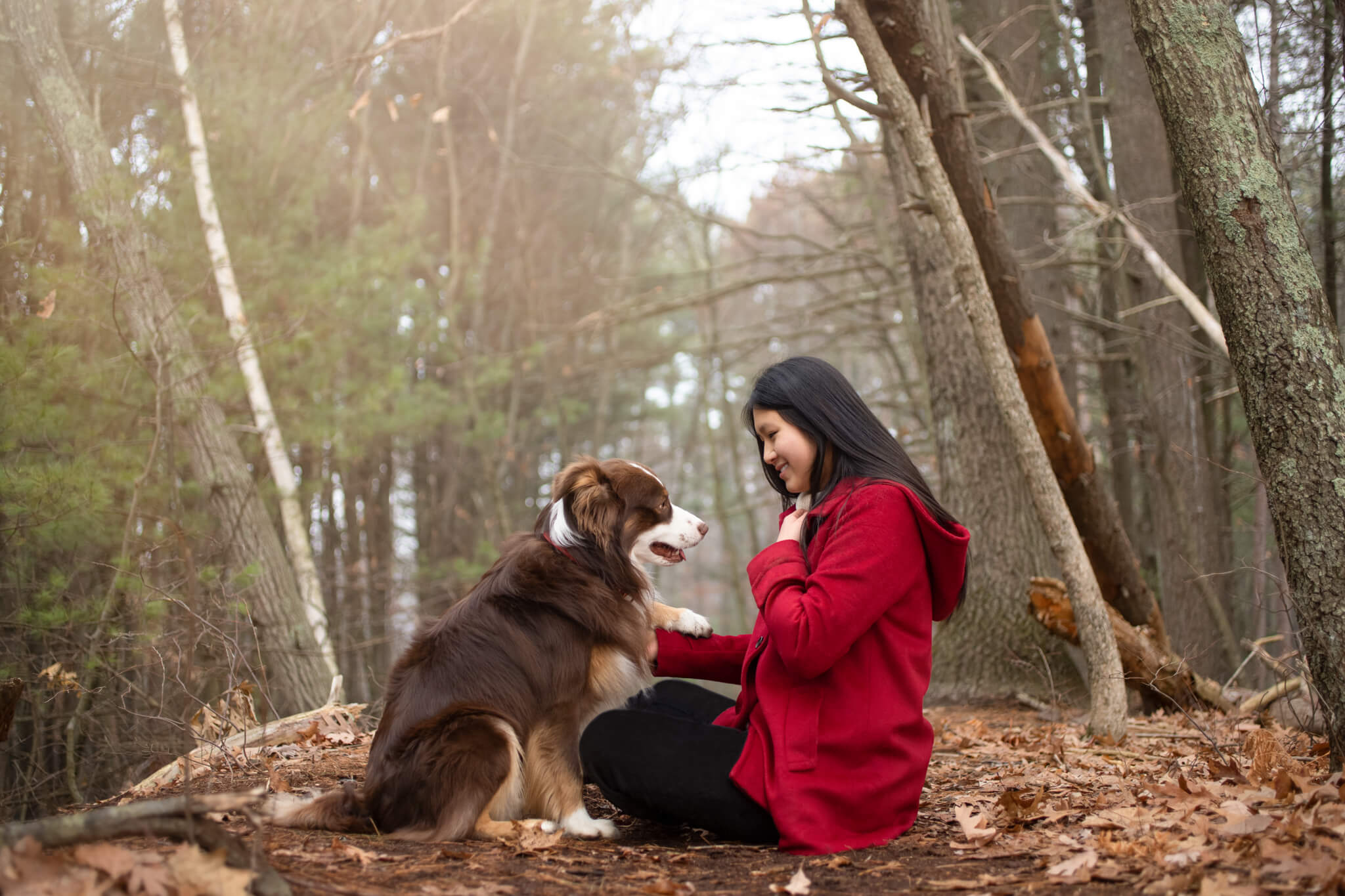 woman in red shaking hands with her pup in the woods Bark N Roll Reading MA